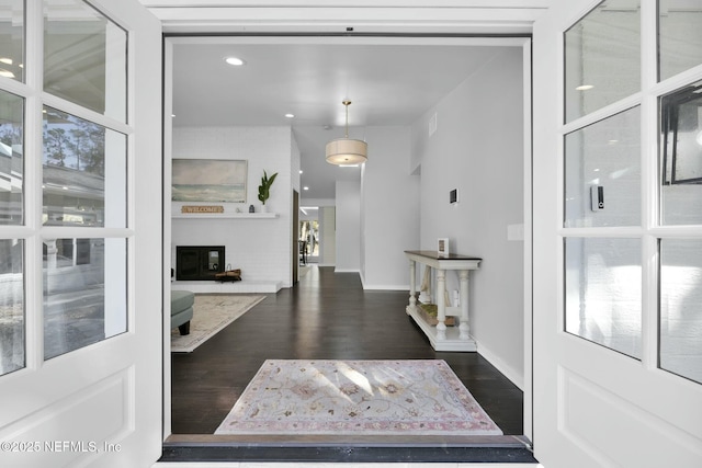 foyer with a fireplace and dark wood-type flooring