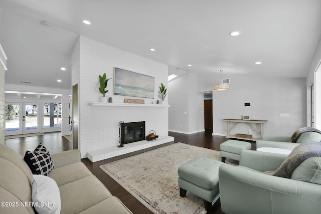 living room featuring a fireplace, vaulted ceiling, dark hardwood / wood-style floors, and french doors