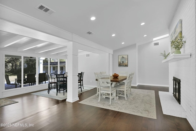 dining area featuring vaulted ceiling with beams, a fireplace, and dark hardwood / wood-style flooring