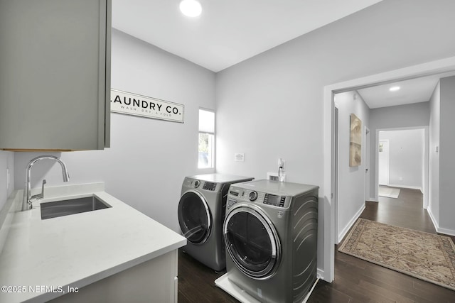 washroom featuring separate washer and dryer, sink, cabinets, and dark hardwood / wood-style floors