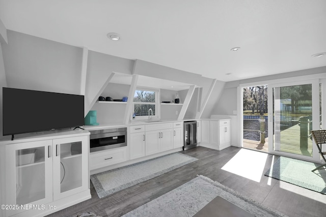 living room with sink, dark hardwood / wood-style floors, and beverage cooler