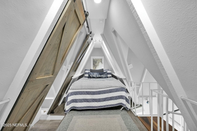 bedroom with hardwood / wood-style floors and a barn door