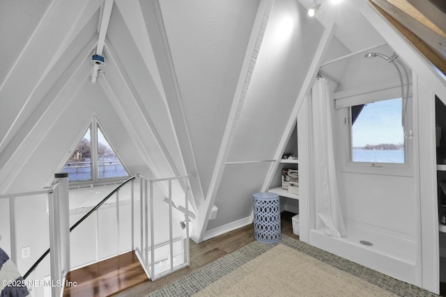 bonus room featuring vaulted ceiling with beams, wood-type flooring, and plenty of natural light