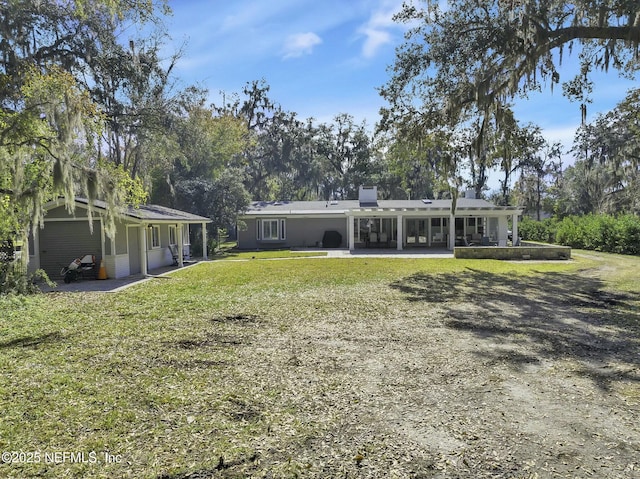 rear view of property with a yard and a patio