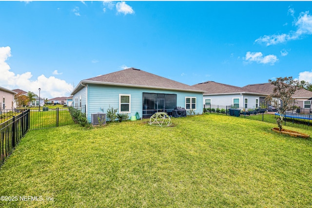 rear view of house featuring a yard and central AC