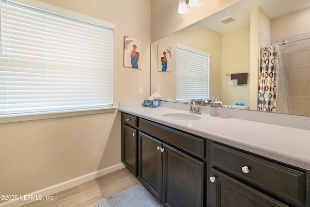 bathroom featuring walk in shower and vanity