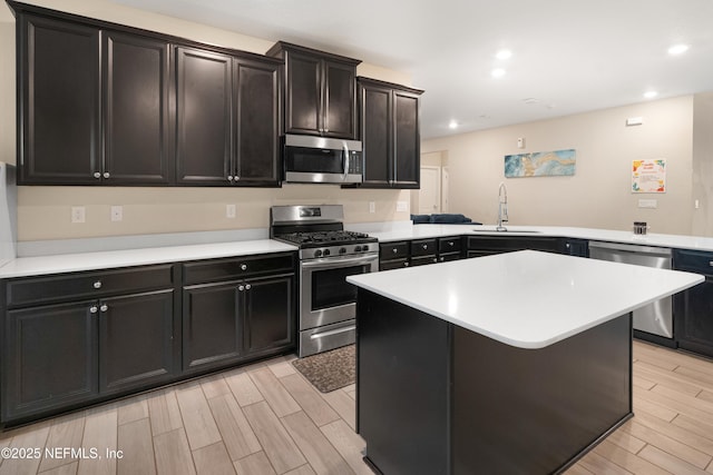 kitchen with a kitchen bar, sink, kitchen peninsula, a kitchen island, and stainless steel appliances