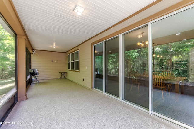 unfurnished sunroom with a notable chandelier