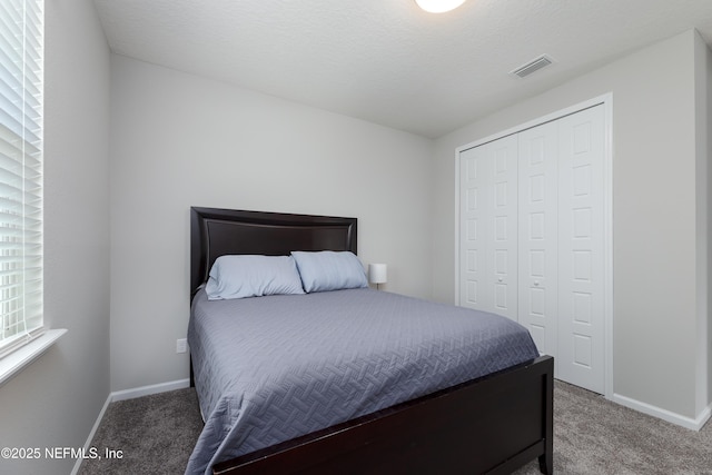 bedroom with carpet floors, a textured ceiling, and a closet