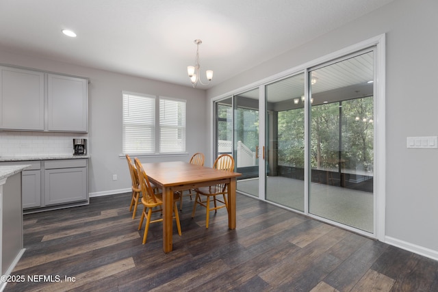 dining space with dark hardwood / wood-style floors and a notable chandelier