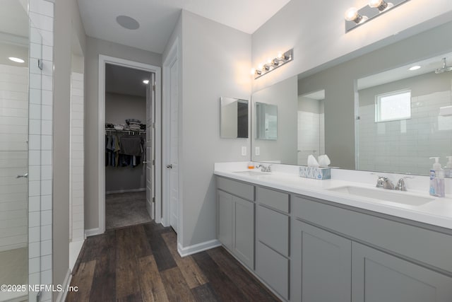 bathroom featuring vanity, hardwood / wood-style floors, and a tile shower