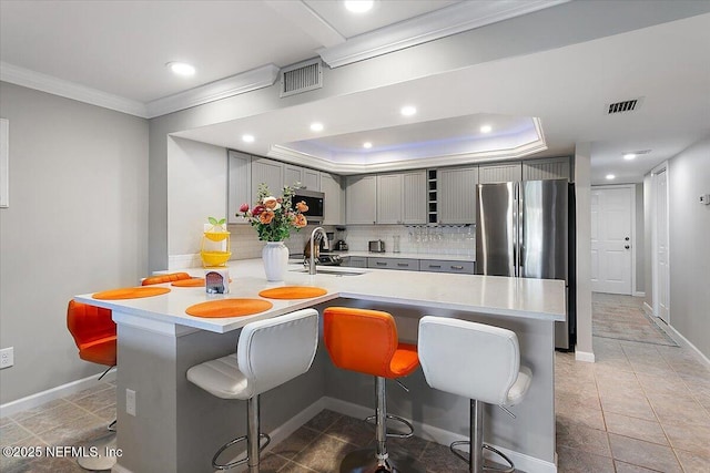 kitchen with stainless steel appliances, kitchen peninsula, sink, and a breakfast bar area