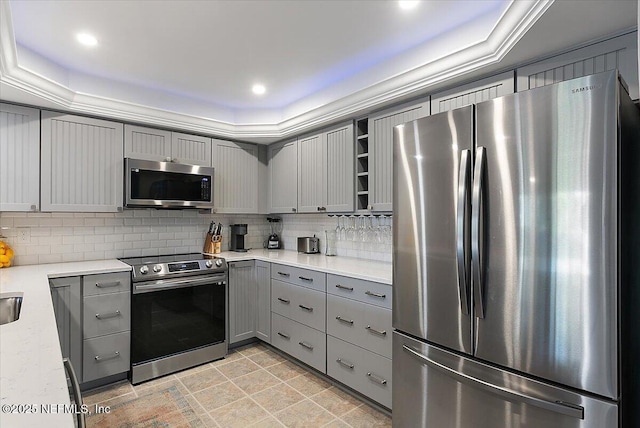 kitchen featuring gray cabinets, tasteful backsplash, appliances with stainless steel finishes, and light tile patterned floors