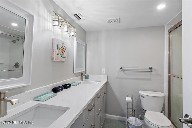 bathroom featuring vanity, a shower with door, and toilet