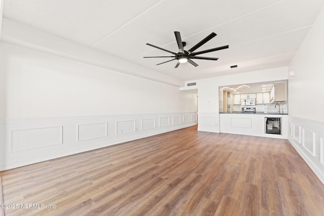 2280 Shepard St Unit 204, Jacksonville, FL 32211 - unfurnished living room featuring wine cooler, ceiling fan, sink, and light wood-type flooring