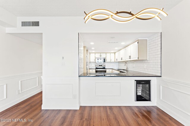 2280 Shepard St Unit 204, Jacksonville, FL 32211 - kitchen featuring decorative light fixtures, white cabinetry, sink, beverage cooler, and stainless steel appliances