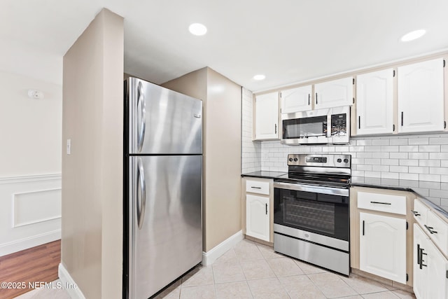 2280 Shepard St Unit 204, Jacksonville, FL 32211 - kitchen featuring backsplash, light tile patterned floors, stainless steel appliances, and white cabinets