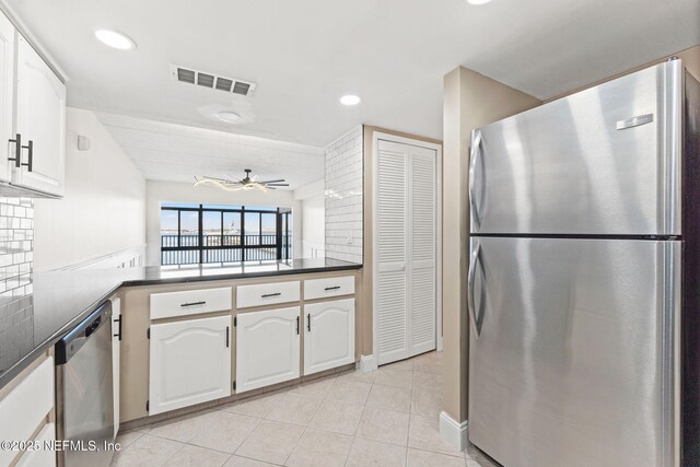 2280 Shepard St Unit 204, Jacksonville, FL 32211 - kitchen with white cabinets, light tile patterned floors, ceiling fan, kitchen peninsula, and stainless steel appliances