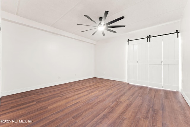 2280 Shepard St Unit 204, Jacksonville, FL 32211 - unfurnished bedroom featuring dark wood-type flooring, ceiling fan, and a barn door
