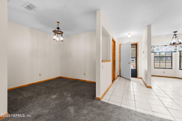 tiled entrance foyer featuring a notable chandelier and a textured ceiling