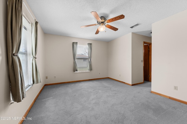 carpeted spare room with ceiling fan and a textured ceiling