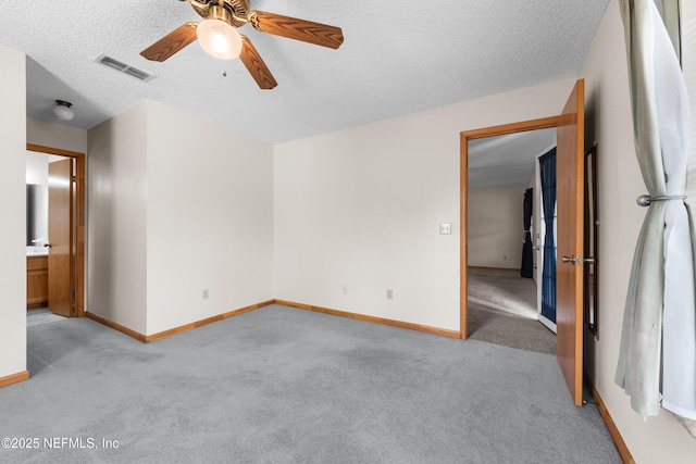 carpeted spare room with ceiling fan and a textured ceiling