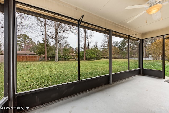 unfurnished sunroom featuring ceiling fan