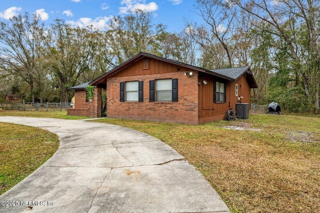 view of front of home with central AC unit and a front yard