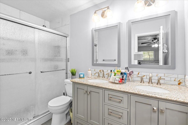 bathroom featuring a shower with shower door, vanity, baseboard heating, toilet, and a textured ceiling