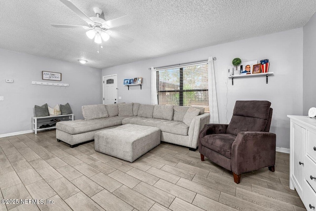 living room featuring ceiling fan, a textured ceiling, and light wood-type flooring