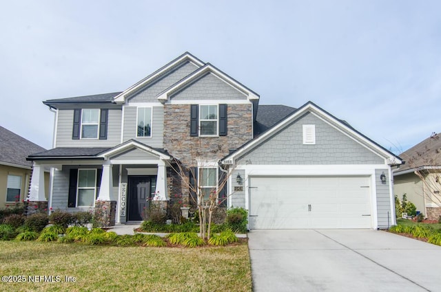 craftsman house with a garage, stone siding, concrete driveway, and a front yard