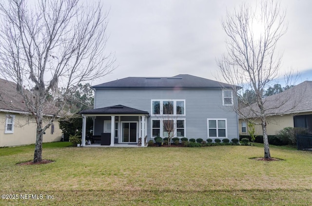 back of house featuring a patio area and a lawn