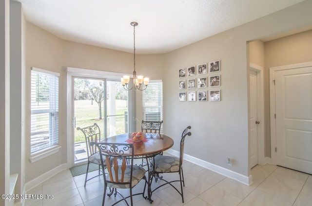 dining room with light tile patterned floors, a healthy amount of sunlight, baseboards, and an inviting chandelier