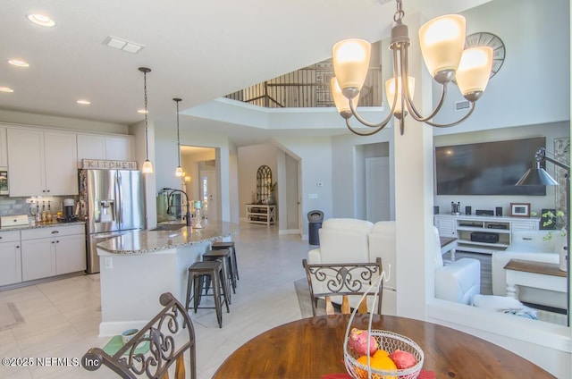 kitchen featuring appliances with stainless steel finishes, a chandelier, white cabinetry, and open floor plan