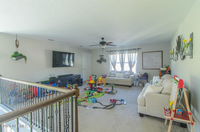 living room featuring carpet floors, visible vents, ceiling fan, and a textured ceiling