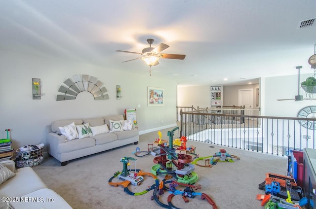 living area featuring baseboards, carpet floors, visible vents, and a ceiling fan