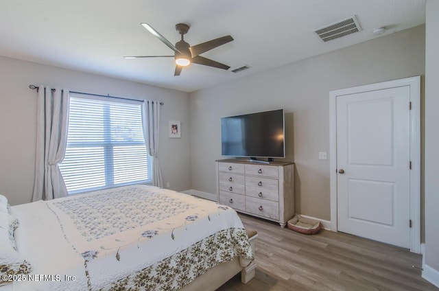 bedroom featuring visible vents, ceiling fan, light wood-style flooring, and baseboards