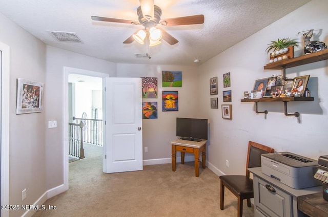 home office with light carpet, ceiling fan, visible vents, and baseboards