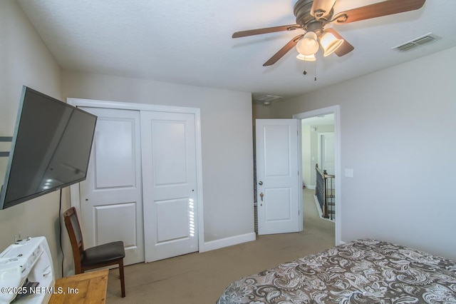 bedroom with a closet, light colored carpet, visible vents, ceiling fan, and baseboards