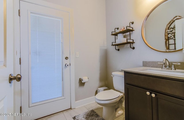 bathroom featuring tile patterned flooring, baseboards, vanity, and toilet