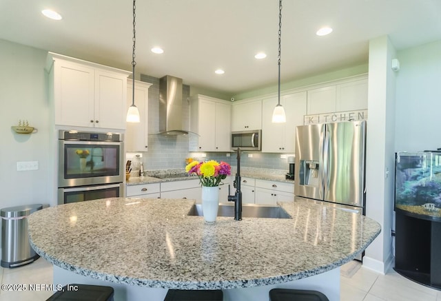 kitchen with white cabinets, stainless steel appliances, and wall chimney range hood