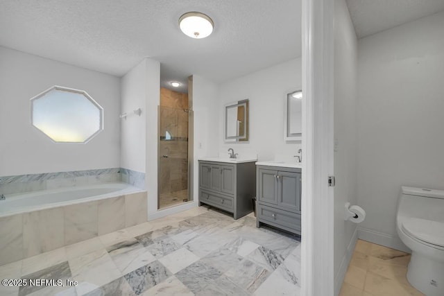 full bathroom with vanity, separate shower and tub, a textured ceiling, and toilet