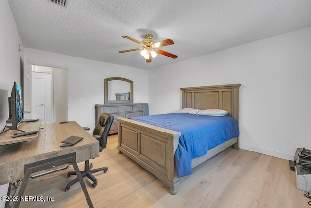 bedroom featuring ceiling fan, a textured ceiling, and light wood-type flooring