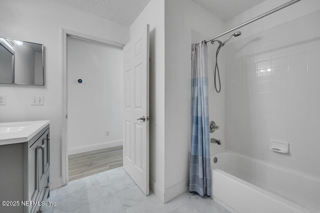 bathroom with shower / bath combo, vanity, and a textured ceiling