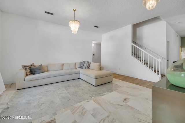 unfurnished living room featuring a notable chandelier and a textured ceiling