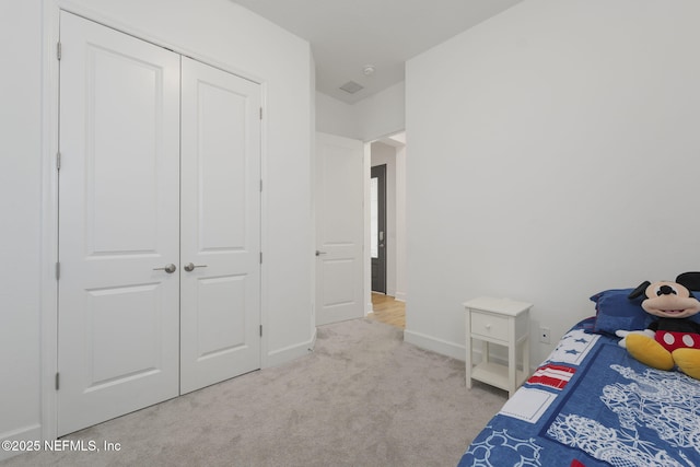 bedroom featuring light carpet and a closet