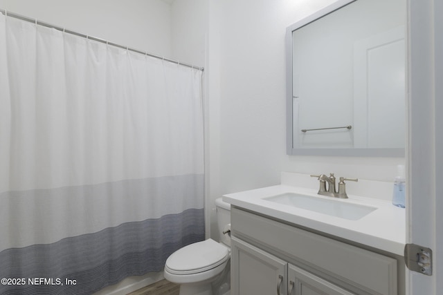 bathroom with vanity, curtained shower, and toilet