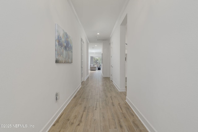 hall featuring crown molding and light wood-type flooring