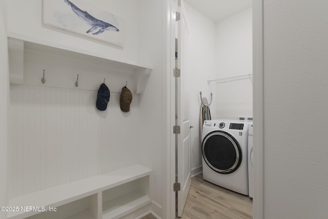 laundry room with washer / dryer and light hardwood / wood-style flooring