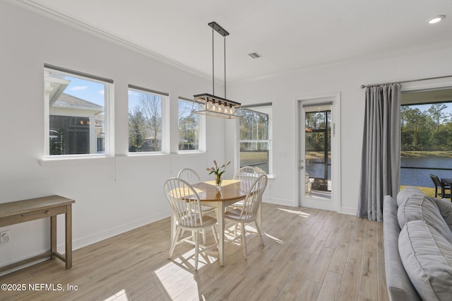 dining room featuring crown molding and light hardwood / wood-style flooring